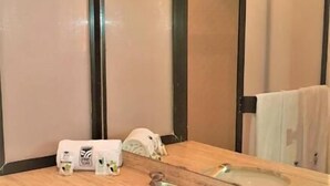 Un baño moderno con tocador de madera, un lavabo y un espejo.