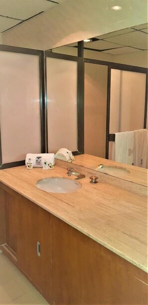 A modern bathroom with a wooden vanity, a sink, and a mirror. - Hotel Finisterre  (Mexico City)