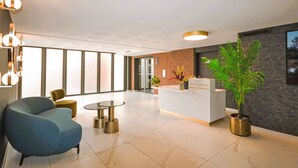 A modern lobby with a reception desk, seating area, and large windows. - Pigonnet by Interhome (Aix en Provence)