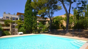 A swimming pool with clear blue water, surrounded by trees and buildings. - Pigonnet by Interhome (Aix en Provence)