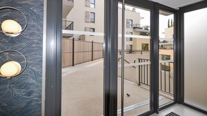 A modern building with a glass entrance, a metal railing, and a patterned wall. - Pigonnet by Interhome (Aix en Provence)