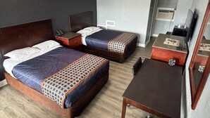 Een hotelkamer met twee bedden, een bureau en een stoel.