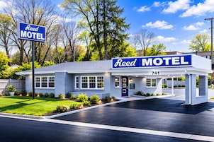 A motel with a blue sign, a number 741, and a covered parking area.