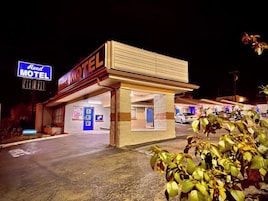 A motel with a sign reading "Reed Motel" and an entrance sign.