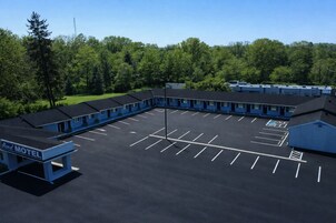 A motel with a parking lot and multiple motel units.