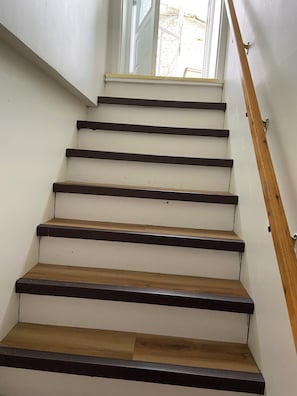 A staircase with wooden steps and a wooden handrail.