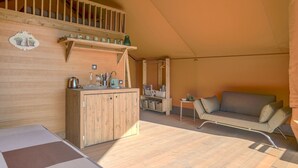 Ein gemütliches Zimmer mit einer Holz-Kochnische, einem Sofa und einem Esstisch.