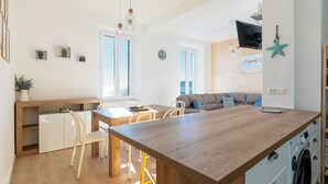 Een moderne keuken met een houten kookeiland, witte kastjes en een inbouw wasmachine.