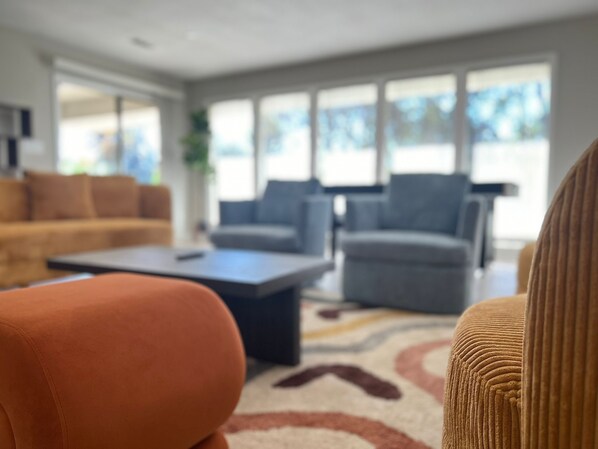 A modern living room with a sofa, armchairs, and a coffee table.