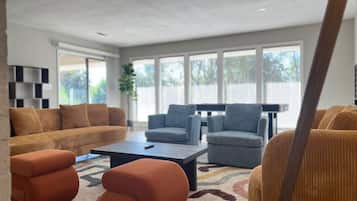 Un salon moderne avec un canapé, des fauteuils et une table basse.
