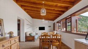 A dining area with wooden furniture, a ceiling with exposed beams, and large windows offering a view of the outdoors. - 'Tilo' Apartment with Mountain Views, Wi-Fi and Air Conditioning - SilboHolidays (Santa Cruz de Tenerife.)