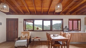 A dining area with wooden furniture, large windows, and a view of the outdoors. - 'Tilo' Apartment with Mountain Views, Wi-Fi and Air Conditioning - SilboHolidays (Santa Cruz de Tenerife.)