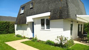 A two-story house with a dark roof, white siding, and a small front porch. - Scheldeveste 157 Breskens (Breskens)
