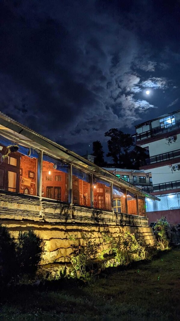 A building with a stone facade and a flat roof, under a night sky with a visible moon.