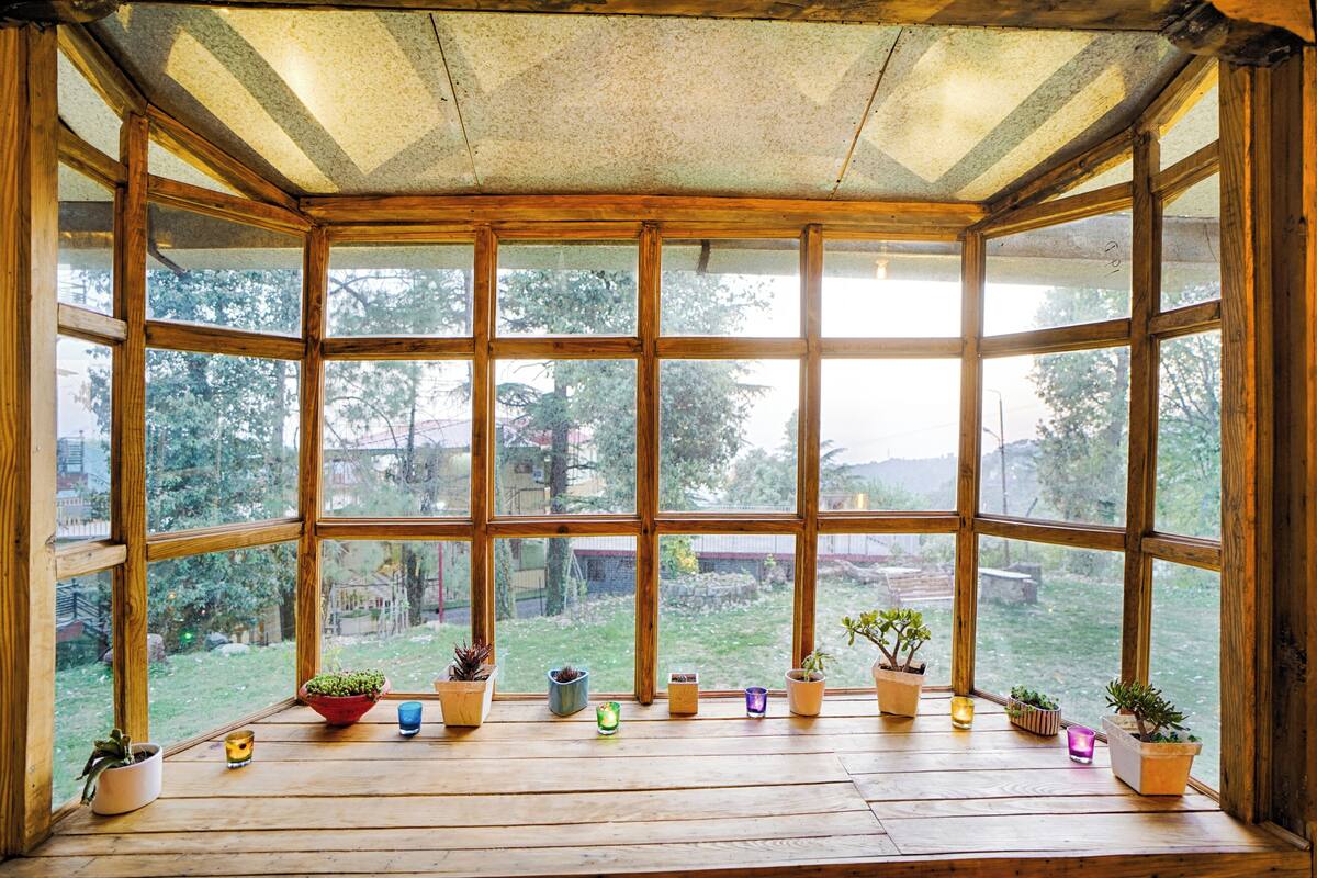A conservatory with a wooden floor and large windows.