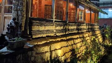 A traditional building with a stone facade, large windows, and a balcony.