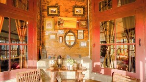 Un intérieur rustique avec des murs en bois, des tableaux encadrés et une table en bois entourée de chaises.