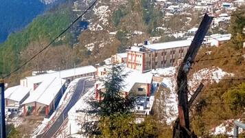 A mountainous landscape with buildings, a ski lift, and a snow-covered foreground.