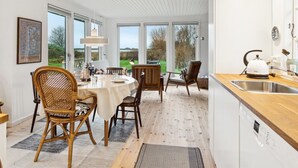 A modern kitchen with a wooden countertop, a Bosch dishwasher, and a view of the outdoors.