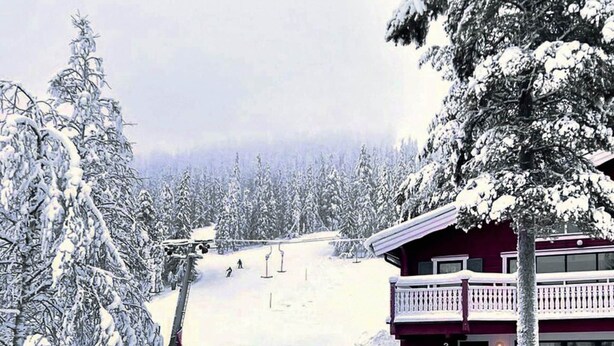 A snow-covered ski resort with a red building, snow-covered trees, and a ski lift in the background. - 7 Person Holiday Home in Salen (Transtrand)
