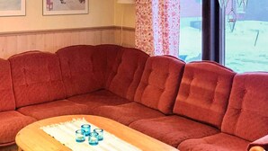 A red sectional sofa with a wooden coffee table in front. - 7 Person Holiday Home in Salen (Transtrand)