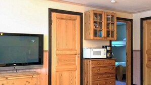 A room with a wooden cabinet, a microwave, and a television on a wooden dresser. - 7 Person Holiday Home in Salen (Transtrand)