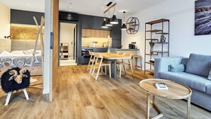 A modern living room with a sofa, a coffee table, and a dining area with a table and chairs. - Levandule by Interhome (Abertamy)