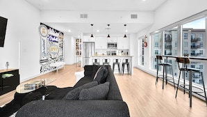 A modern apartment with a living area, kitchen, and dining space.
