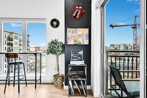 Una sala de estar moderna con un ventanal grande, un tocadiscos de vinilo y la portada enmarcada del álbum de los Beatles.
