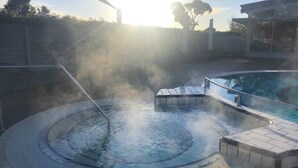 Een warmwaterbrongebied met een zwembad en stoom die uit het water opstijgt.