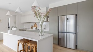 Een moderne keuken met een groot schiereiland, roestvrijstalen apparatuur en een vaas met bloemen.
