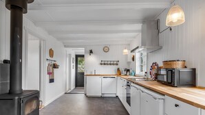A modern kitchen with white cabinetry, a black stove, and a wooden countertop. - "Blomma" - 1km from the sea by Interhome (Ebeltoft)