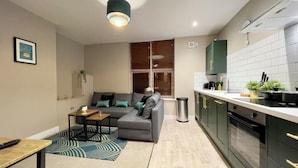 A modern apartment with a living area, kitchenette, and a dining space. - Stay Angels - Cosy Boho Apartment (Sheffield)