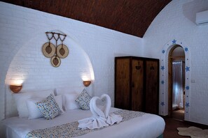 Relax in a traditional room with a large bed, wooden wardrobe, and wall-mounted light fixture.