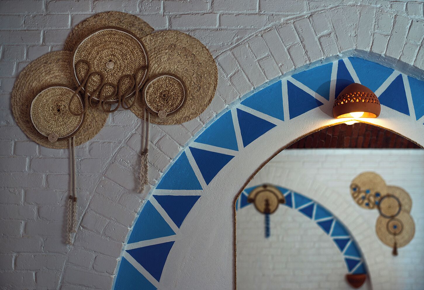 Un mur orné de paniers tressés et d’un luminaire décoratif.
