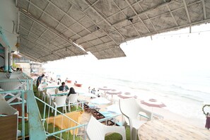 Di pantai, pasir putih, kursi berjemur, dan payung pantai