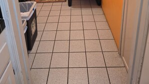 A narrow hallway with orange walls, a tiled floor, a door with a window, a chair, and a trash bin. - 6 blocks to Santa Monica beach, great neighborhood  (Santa Monica)