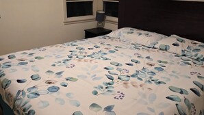 A bedroom with a bed, a nightstand, a window, and a dark headboard. - 6 blocks to Santa Monica beach, great neighborhood  (Santa Monica)