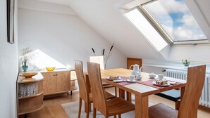 Ein Essbereich mit Holztisch, Stühlen und einem Oberlicht.