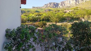 A balcony with a view of a vineyard and rocky hills in the distance. - TENUTE LAZZARINO (Sciacca)