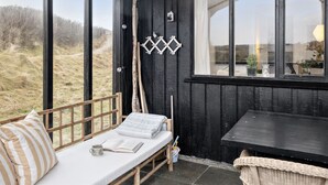 A cozy room with a wooden bench, a small table, and a view of the outdoors.