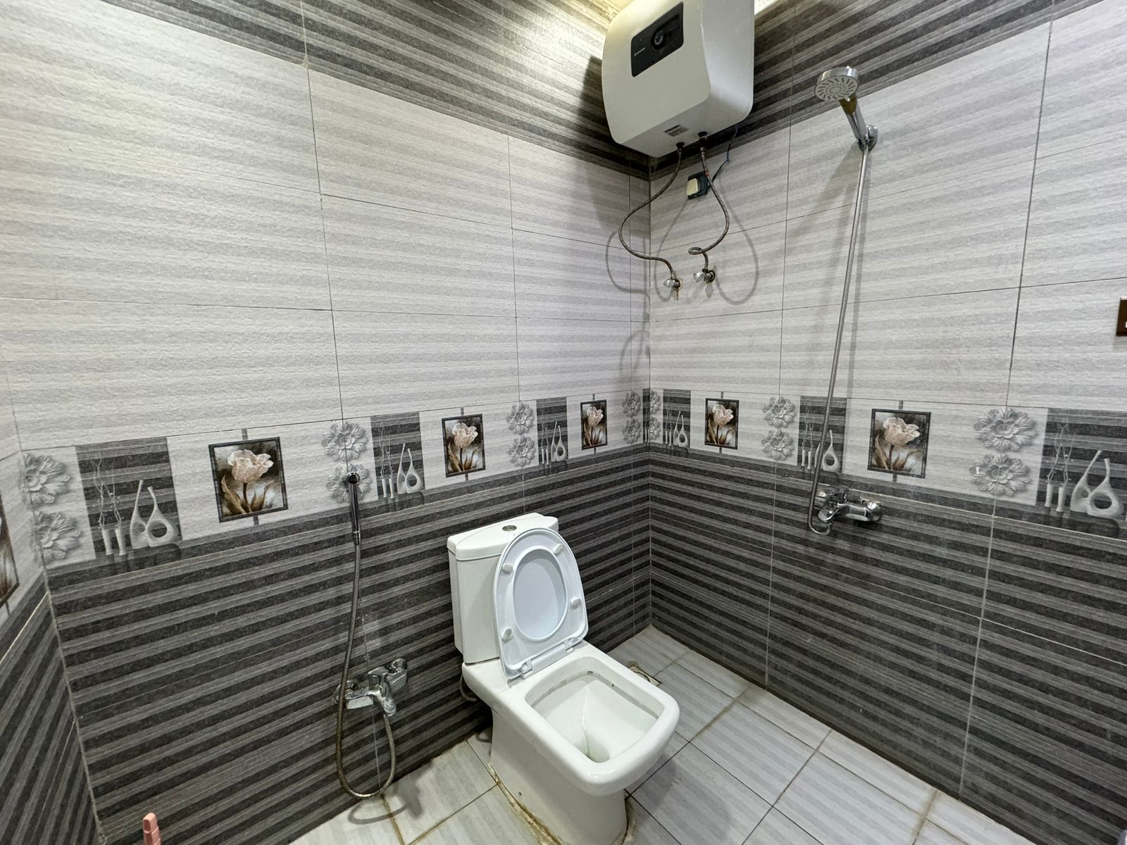 Ein Badezimmer mit Toilette, Dusche und einem Händetrockner.