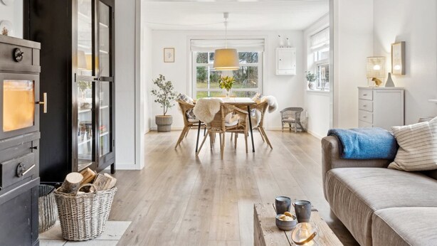 A modern living room with a sofa, a dining table with chairs, a fireplace, and a view of the outdoors. - "Nayeli" - 1.2km from the sea by Interhome (Vejby)