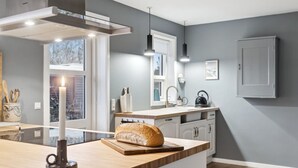 A modern kitchen with a large island, a built-in oven, and a window overlooking a brick wall. - "Nayeli" - 1.2km from the sea by Interhome (Vejby)