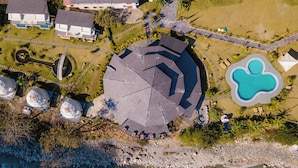 An aerial view of a coastal property with a swimming pool, a gazebo, and a rocky shoreline. - Harness Zipline And Adventure Resort (Godaam)
