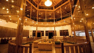 A spacious interior with a high wooden ceiling, multiple levels, and a central seating area.
