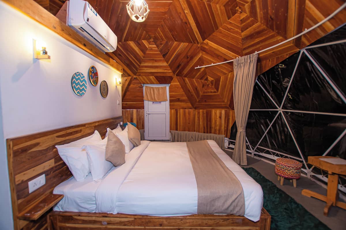 A cozy, wooden-themed bedroom with a bed, bedside table, and a wardrobe.