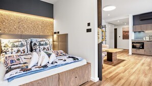 Een moderne slaapkamer met een groot bed, een houten hoofdbord en een ingebouwde bank.