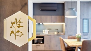Een moderne keuken met houten kastjes, een inbouwoven en een hanglamp.