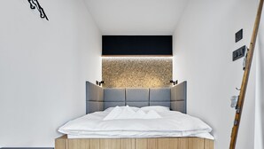 A modern bedroom with a built-in bed, wooden flooring, and a textured wall above the bed. - Lovely apartment for 6 people with WIFI, A/C, TV and balcony (Ostrov)